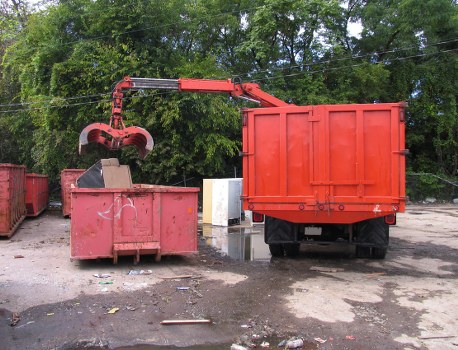 Crew preparing a commercial waste vehicle for collection